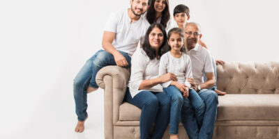Indian asian family sitting on sofa or couch over white background